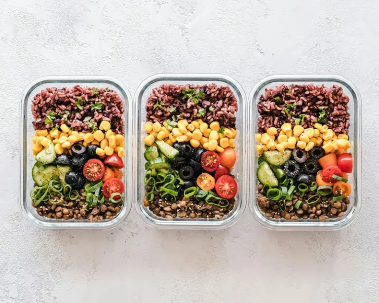 Colorful Meal Prep Bowls with Rice, Corn, Cucumbers, Olives, and Cherry Tomatoes Neatly Arranged